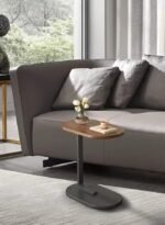 طاولة القهوة والخدمة الجانبية الذكية سوداء اللون بتصميم حرف C موضوعة بجانب أريكة بذكاء وبامتياز